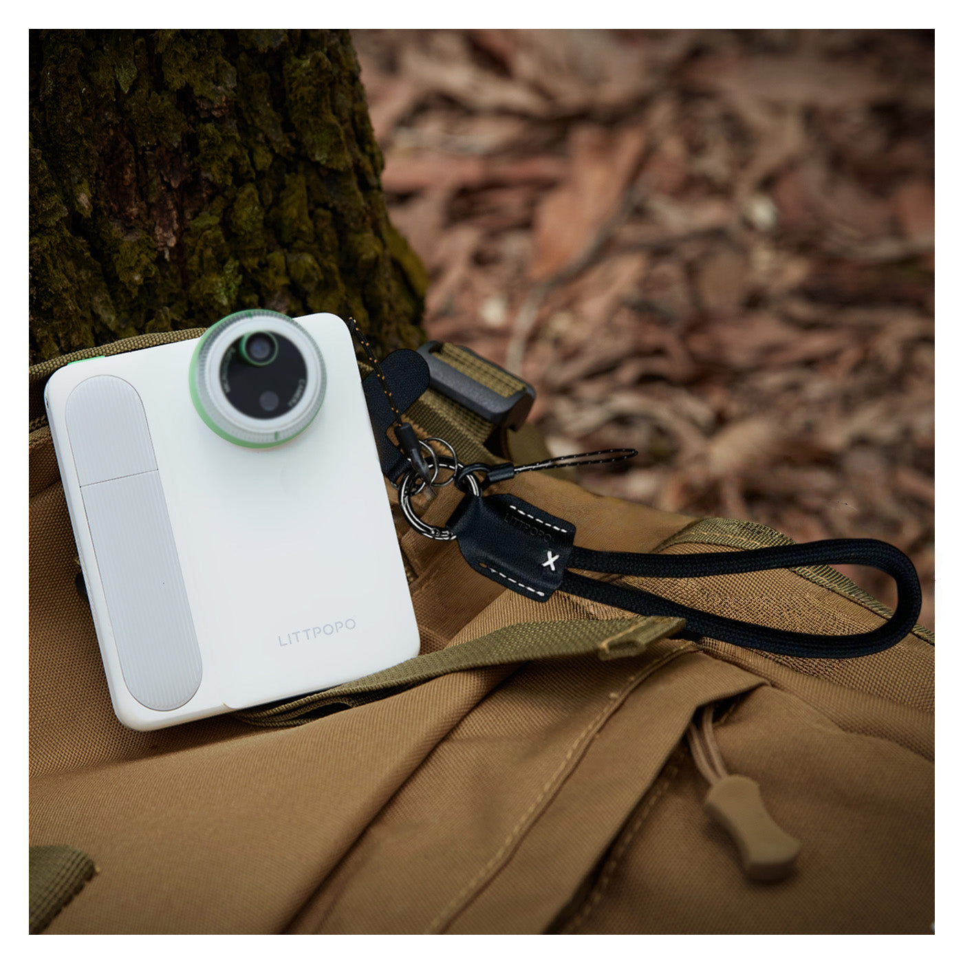 Littpopo MicroCam X1 camera with green lens on a brown bag in a natural setting